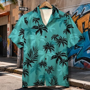 May include: A short-sleeved button-down shirt with a teal background and a pattern of black palm trees. The shirt is hanging on a wooden hanger. The shirt has a classic collar and a relaxed fit, perfect for a tropical vacation.