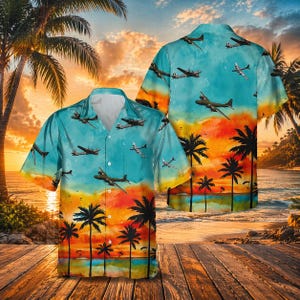 May include: A short-sleeved shirt with a tropical design. The shirt has a sky blue background with images of airplanes. The bottom of the shirt features a sunset scene with palm trees and a beach.