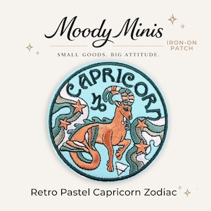 May include: A circular iron-on patch featuring an embroidered Capricorn zodiac design. The patch displays a central orange sea-goat creature on a light blue background, surrounded by dark green wavy lines and orange stars. Text reads Moody Minis.