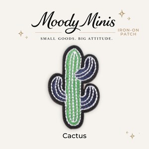 May include: An embroidered iron-on patch shaped like a cactus with a central light green column and dark blue side arms, all outlined in black. The text Moody Minis, IRON-ON PATCH, SMALL GOODS. BIG ATTITUDE., and Cactus appears in the image.