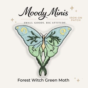 May include: An embroidered iron-on patch featuring a moth with light blue and green wings, yellow crescent moon accents, and dark green branch-like patterns. The text Moody Minis, IRON-ON PATCH, SMALL GOODS. BIG ATTITUDE., and Forest Witch Green Moth is visible.