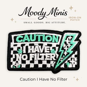 May include: A rectangular iron-on patch featuring a black and white checkered background with the embroidered text CAUTION I HAVE NO FILTER in mint green and white. A mint green lightning bolt graphic is on the right side of the patch.