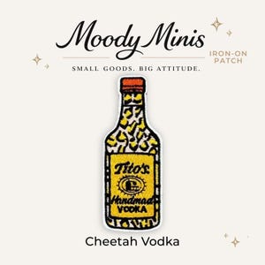 May include: An embroidered iron-on patch shaped like a bottle with an orange cap. The top half features a black and white cheetah print pattern, while the bottom half is a yellow label with black text reading Tito's Handmade Vodka.