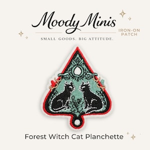 May include: A triangular iron-on patch featuring two black cats facing each other on a light green background with red and black borders. The text Moody Minis, IRON-ON PATCH, SMALL GOODS. BIG ATTITUDE., and Forest Witch Cat Planchette are visible.