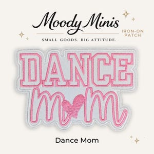 May include: An iron-on patch featuring the text DANCE MOM in pink and white embroidery. The word DANCE is in a bold block font, while MOM is in a cursive script with a pink embroidered heart replacing the letter O. The patch has a white border.