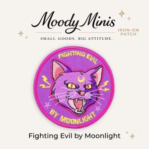 May include: A circular iron-on patch featuring a purple cat with yellow eyes and a yellow crescent moon on its forehead. The text reads Fighting Evil by Moonlight in yellow letters. The patch has a bright pink border and lightning bolt accents.