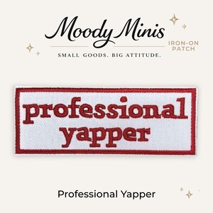 May include: A rectangular iron-on patch with a white background and a red border. The text 'professional yapper' is embroidered in red, lowercase, sans-serif letters across the center. The patch is branded with 'Moody Minis' text above.
