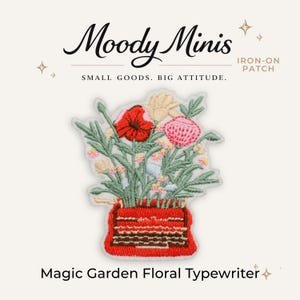 May include: An embroidered iron-on patch featuring a red typewriter with a bouquet of flowers in shades of red, pink, yellow, and blue. The text Moody Minis, Small Goods. Big Attitude. and Magic Garden Floral Typewriter are visible.
