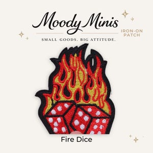 May include: An embroidered iron-on patch featuring two red dice with white pips engulfed in stylized yellow and orange flames with a black border. The text Moody Minis, Iron-On Patch, Small Goods. Big Attitude., and Fire Dice is visible.
