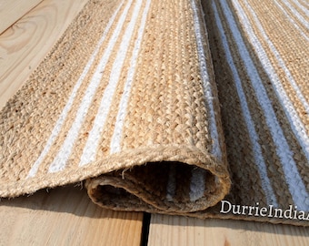 May include: A natural fiber rug with white stripes. The rug is made of jute and is rolled up.