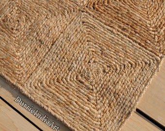 Könnte beinhalten: Ein Naturfaser-Teppich aus Jute mit einem gewebten Muster aus Quadraten. Der Teppich ist hellbraun und hat eine raue Textur.