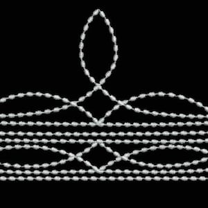 May include: A silver beaded design in the shape of a crown with a pointed top and a rounded base.