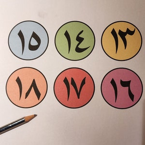 May include: Six colourful circles with Arabic numerals 10 through 17 written in black.
