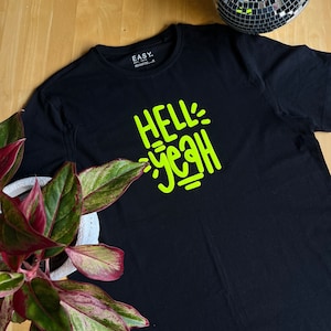 May include: Black t-shirt with a neon green graphic that says "Hell Yeah!"
