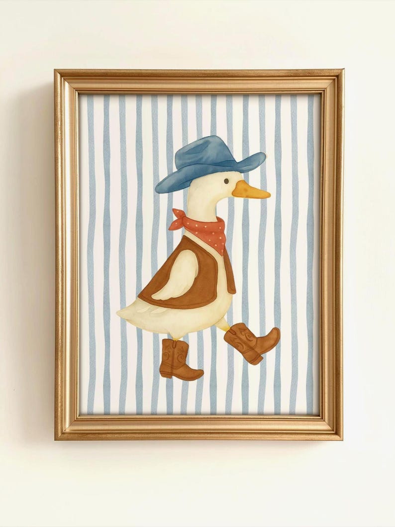 May include: A framed watercolor print features a duck dressed as a cowboy. The duck wears a blue hat, red bandana, brown vest, and cowboy boots. The background has blue and white vertical stripes, and the frame is gold.