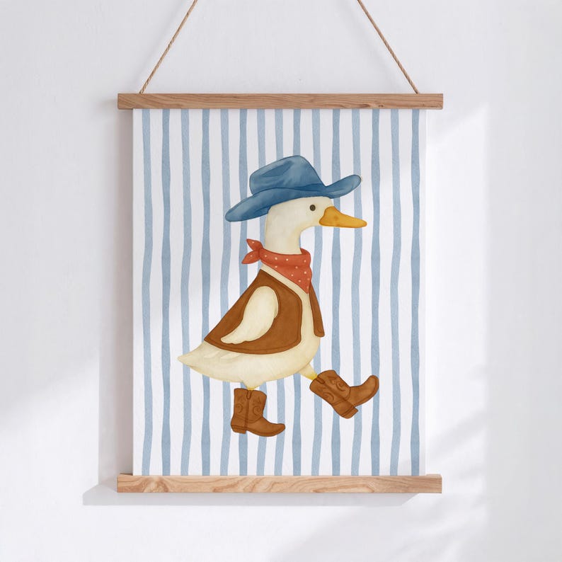 May include: Watercolor illustration of a duck dressed as a cowboy, wearing a blue hat, red bandana, brown vest, and cowboy boots. The duck is walking on a blue and white striped background. The artwork is displayed on a wooden frame.