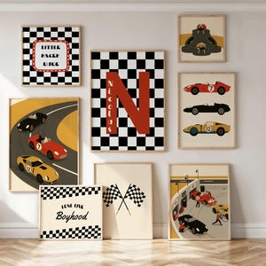 Può includere: Una collezione di opere d'arte da parete incorniciate a tema corse. Le opere d'arte includono motivi a scacchi, auto da corsa e i testi "Little Racer Dude" e "Love Live Boyhood". La tavolozza dei colori presenta rosso, nero, giallo e beige.