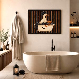 May include: A framed wall art print featuring a white duck sitting in a bathtub filled with dark bubbles and a small orange pumpkin. The background consists of vertical black and orange stripes, and a small black bat is visible on the tub exterior.