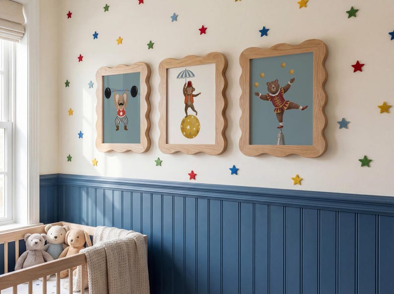 Puede incluir: Tres impresiones enmarcadas de animales de circo con marcos de madera festoneados cuelgan de una pared crema decorada con calcoman&iacute;as en forma de estrella de colores. Las impresiones presentan un perro levantando pesas, un oso sobre una bola y un oso haciendo equilibrio sobre un pedestal.