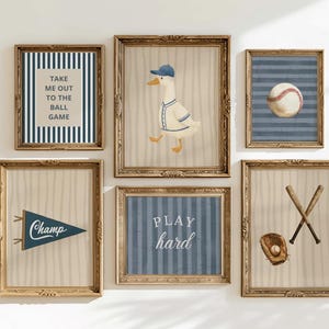 May include: A collection of six framed baseball-themed art prints. The prints depict a baseball, baseball bats, a baseball glove, a duck in a baseball uniform, and text that reads "Take me out to the ball game" and "Play hard". The frames are gold.