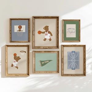 May include: A set of framed wall art with a basketball theme. The art includes illustrations of a bear playing basketball, a basketball hoop, a basketball court, and a pennant that says "GO TEAM". The frames are gold-coloured.