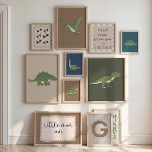 May include: A collection of framed dinosaur-themed art prints in various sizes. The prints feature illustrations of different dinosaurs in shades of green, brown, and blue, with text that reads "RAWR means I love you in Dinosaur" and "Little man cave".