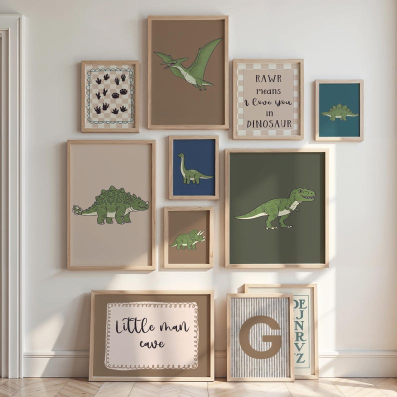 May include: A collection of framed dinosaur-themed art prints in various sizes. The prints feature illustrations of different dinosaurs in shades of green, brown, and blue, with text that reads "RAWR means I love you in Dinosaur" and "Little man cave".
