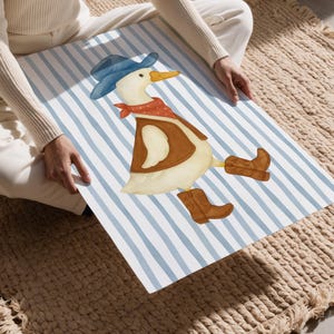 May include: Watercolor illustration of a duck dressed as a cowboy, wearing a blue hat, red bandana, brown vest, and cowboy boots. The duck is on a blue and white striped background.
