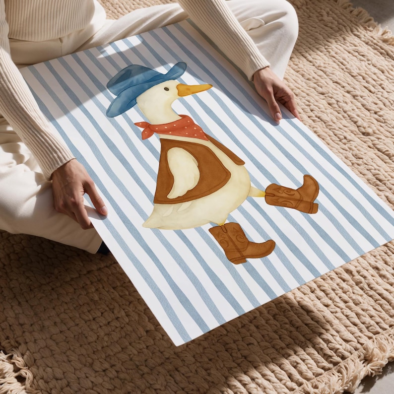 May include: Watercolor illustration of a duck dressed as a cowboy, wearing a blue hat, red bandana, brown vest, and cowboy boots. The duck is on a blue and white striped background.