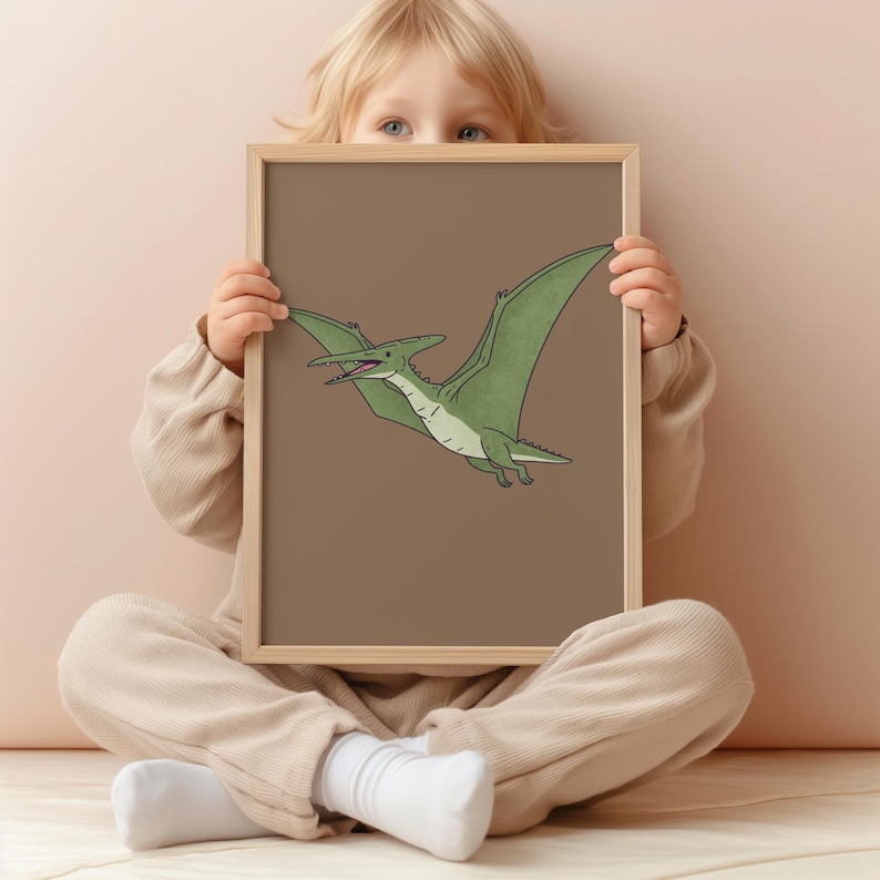 May include: A framed print featuring a green Pterodactyl illustration on a brown background. The artwork depicts the prehistoric flying reptile in flight, with its wings spread. The frame is a light wood color.