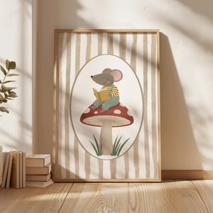 May include: A framed illustration features a cartoon mouse reading a book while seated on a red mushroom with white spots. The mouse wears a striped shirt and overalls. The background has vertical beige and white stripes.