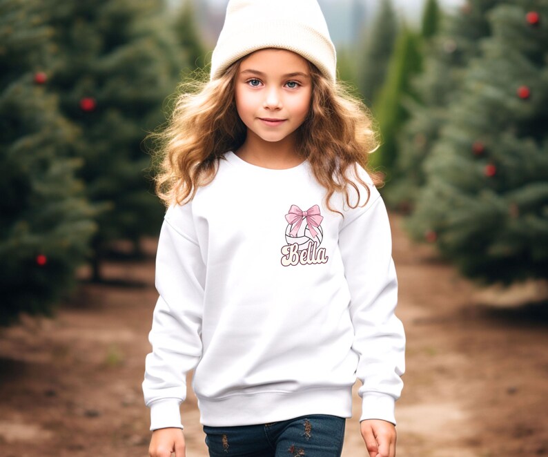 May include: White sweatshirt with a pink bow and the name "Bella" printed on the front.