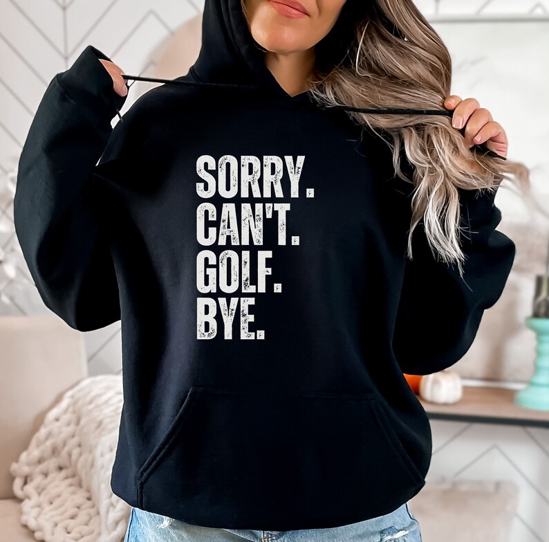May include: Black hooded sweatshirt with the text "SORRY. CAN'T. GOLF. BYE." in white.