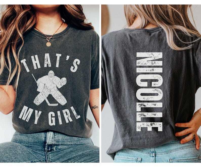 May include: A black t-shirt with a white graphic of a hockey goalie and the text "That's My Girl". The back of the shirt has the name "Nicole" printed in white.