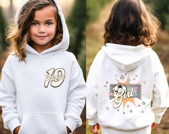 May include: White hooded sweatshirt with a retro-style graphic of the number 19 and the name "Hannah" on the front. The back of the sweatshirt features a graphic of a soccer ball in a goal with the word "Girl" in a retro font.
