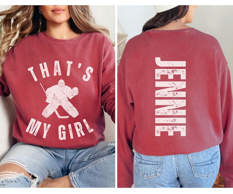May include: Two red sweatshirts with white text. One sweatshirt says "That's My Girl" with a hockey player graphic. The other sweatshirt says "Jennie".