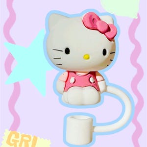 May include: A white Hello Kitty-shaped bottle stopper with a pink bow and dress. The stopper has a curved white straw and a small white cup. The background is light purple with a star, heart, and the text "GRL PWR".