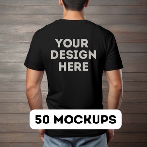 May include: A black t-shirt mockup with the text "YOUR DESIGN HERE" printed on the back. The t-shirt is being worn by a person standing in front of a wood panel background. The text "50 MOCKUPS" is printed in white on a black rectangle at the bottom of the image.