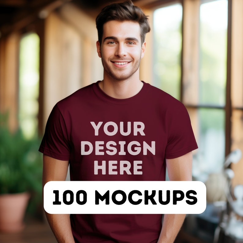May include: A maroon t-shirt mockup with the text "YOUR DESIGN HERE" printed on the front. The text "100 MOCKUPS" is printed on a white rectangle below the shirt.