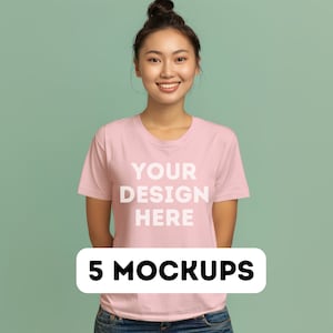 May include: A woman wearing a pink t-shirt with the text "YOUR DESIGN HERE" on it. The text is in white. The woman is smiling and looking at the camera. 5 MOCKUPS is written in black text on a white rectangle.