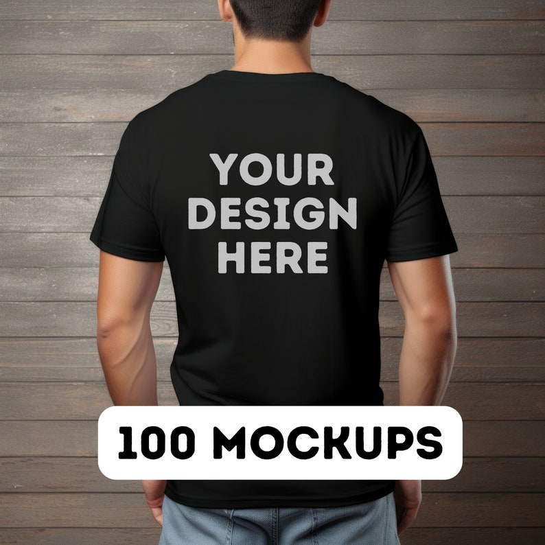May include: A black t-shirt mockup with the text "YOUR DESIGN HERE" printed on the back. The t-shirt is being worn by a person standing in front of a wood panel background.