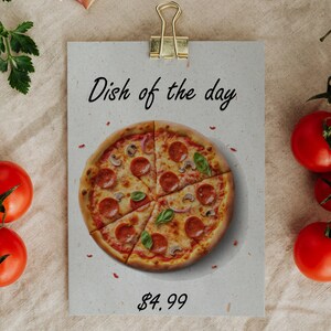 K&ouml;nnte beinhalten: Eine Papierkarte mit dem Text "Gericht des Tages" und einem Foto einer Pepperoni-Pizza mit Pilzen, Zwiebeln und Basilikum. Der Preis betr&auml;gt 4,99 &euro;.