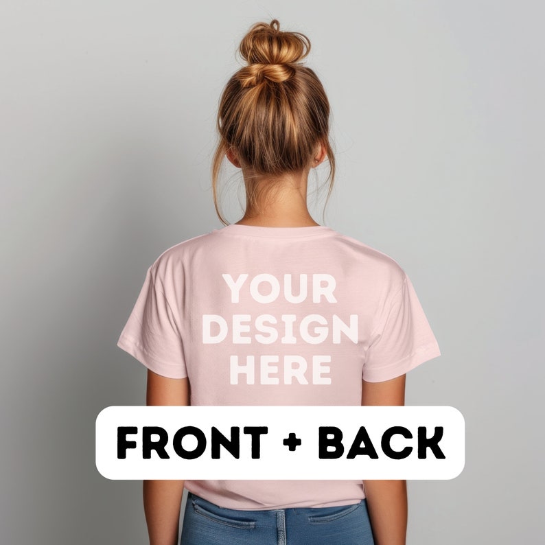 以下が含まれることがあります： 背面に「YOUR DESIGN HERE」という文字が印刷されたピンクのTシャツ。カメラに向かって背を向けている人が着ています。