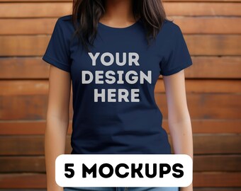 May include: A navy blue t-shirt with the text "YOUR DESIGN HERE" printed on the front. The t-shirt is being worn by a person standing in front of a wooden wall.