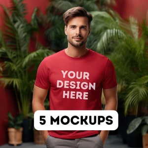 Puede incluir: Un hombre con una camiseta roja con el texto "YOUR DESIGN HERE" impreso en la parte delantera. La camiseta es una maqueta para un proyecto de diseño. 5 MOCKUPS está escrito en negro sobre fondo blanco.