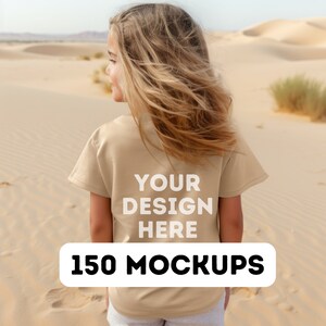 May include: A young person wearing a beige t-shirt with the text "YOUR DESIGN HERE" printed on the back. The person is standing in a desert setting. The text "150 MOCKUPS" is printed in white on a black rectangle at the bottom of the image.