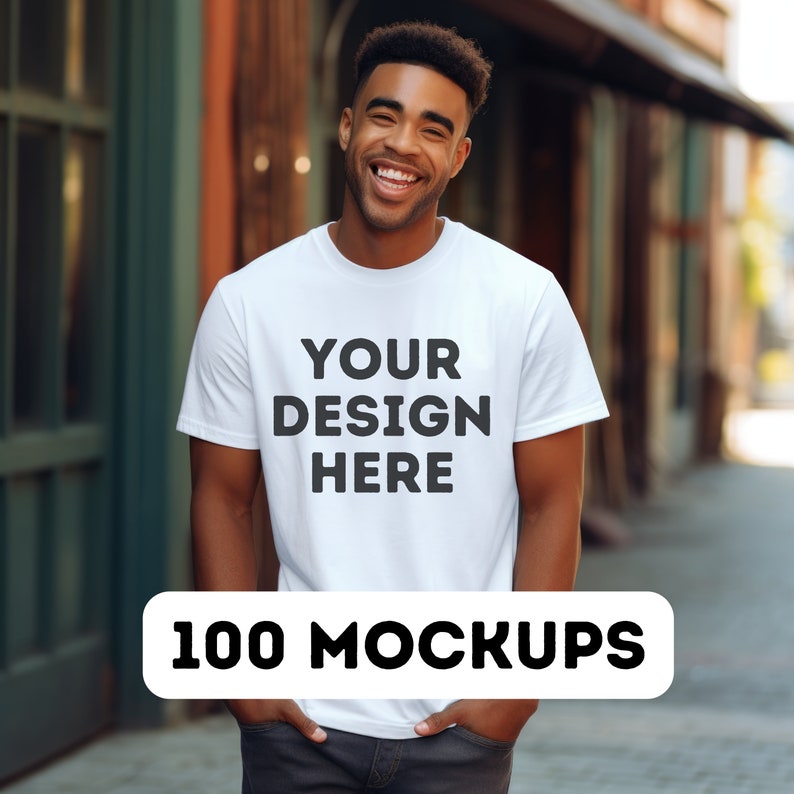 May include: A white t-shirt mockup with the text "YOUR DESIGN HERE" printed on the front. The t-shirt is being worn by a person standing in front of a brick building.