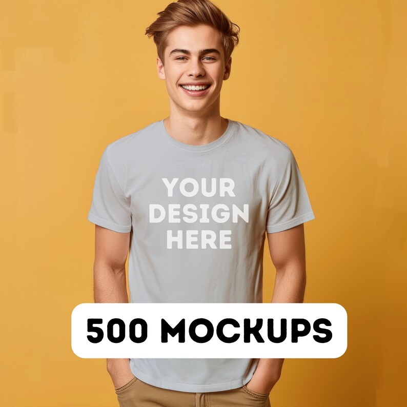 以下が含まれることがあります： 黄色の背景に、薄いグレーのTシャツを着た男性。Tシャツには「YOUR DESIGN HERE」という文字がプリントされています。白い長方形に黒い文字で「500 MOCKUPS」と書かれています。