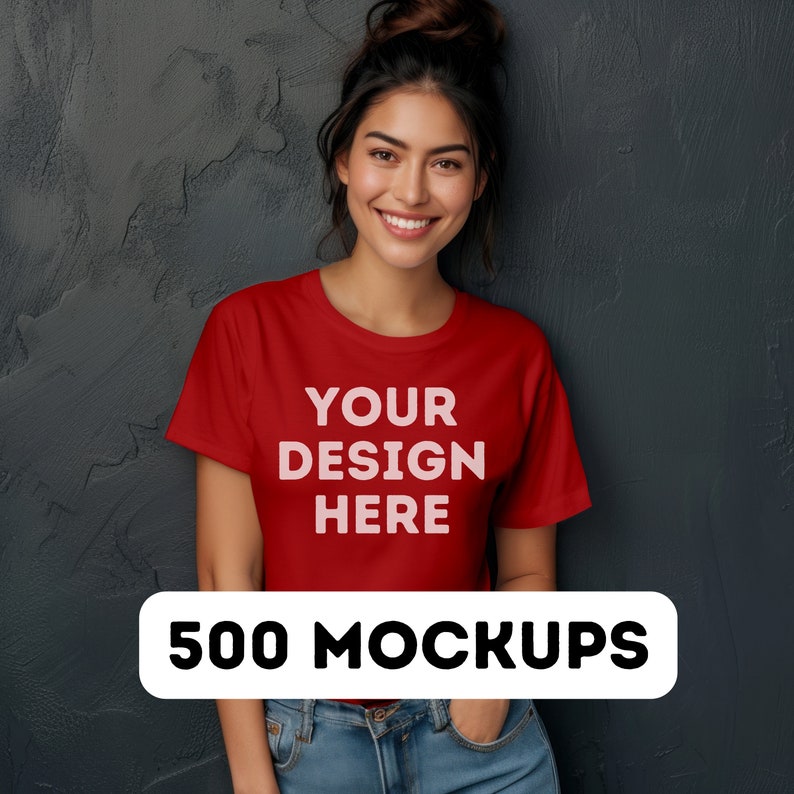 以下が含まれることがあります： 女性が、前面に「YOUR DESIGN HERE」という文字が印刷された赤いTシャツを着ています。Tシャツはデザインプロジェクトのモックアップです。画像の下に「500 MOCKUPS」というテキストが表示されています。