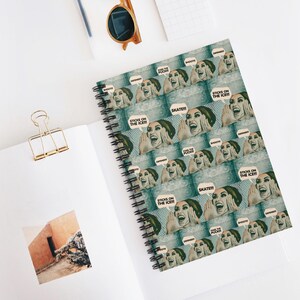 May include: A spiral notebook with a colorful design featuring a woman's face with the text "Skate!!!", "Sticks on the Ice!!!", and "Make the Puck!" repeated throughout the design.